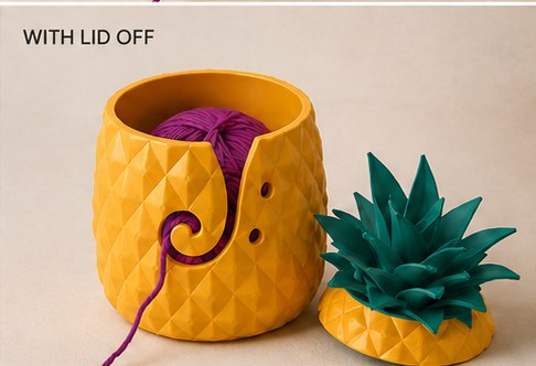 The pineapple yarn bowl with its lid removed, showing the magenta yarn inside.